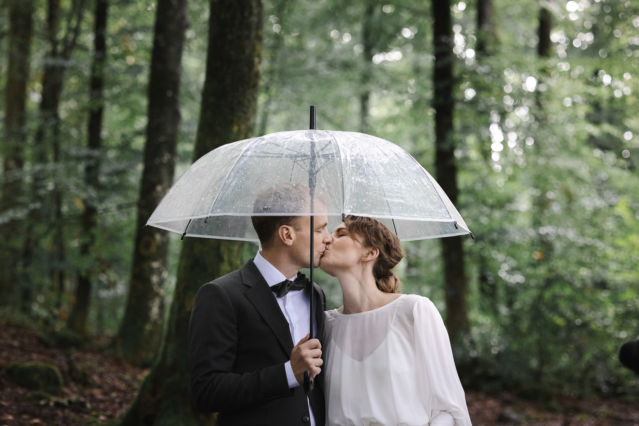 Brud och brudgum under paraply - bröllopsfotografering